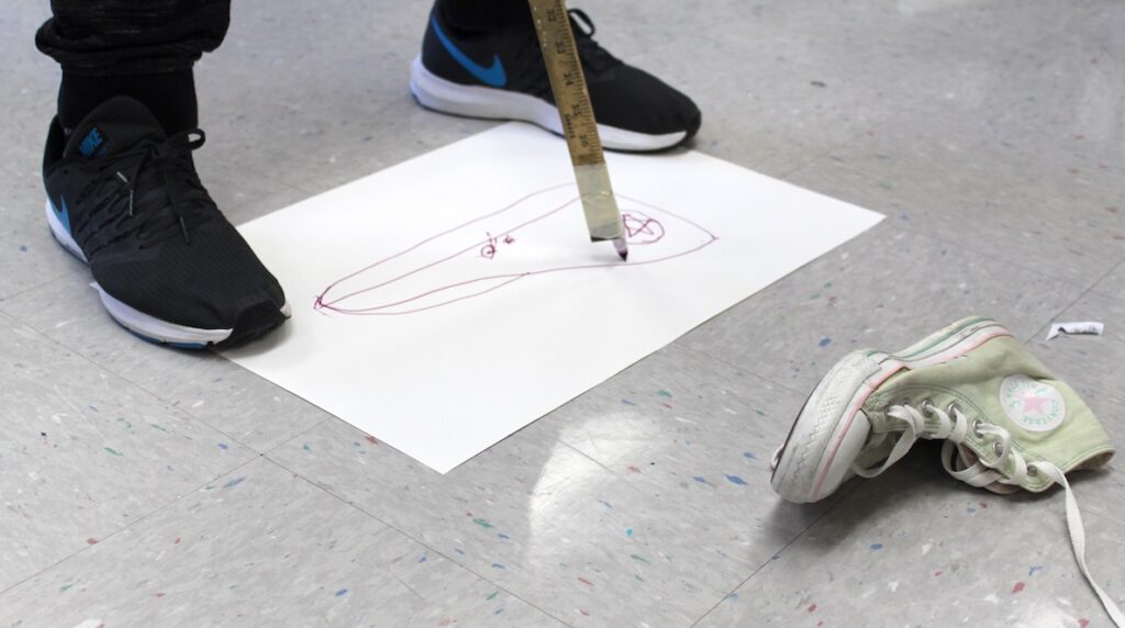 student drawing with a meter stick
