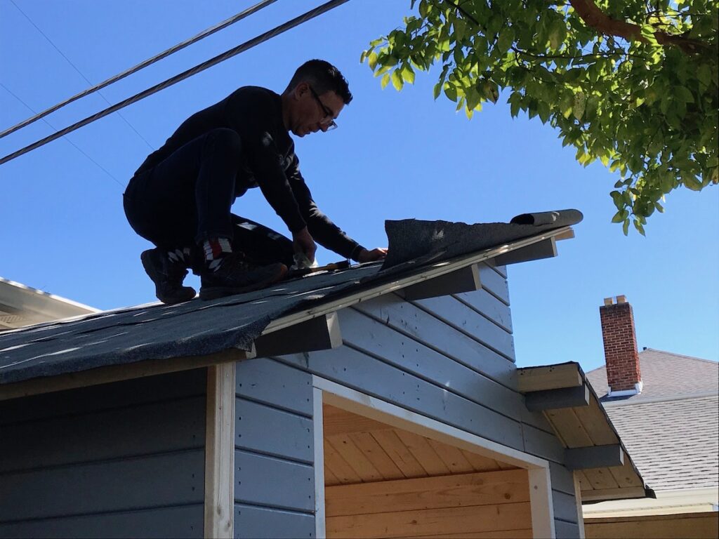 man on roof of a shed