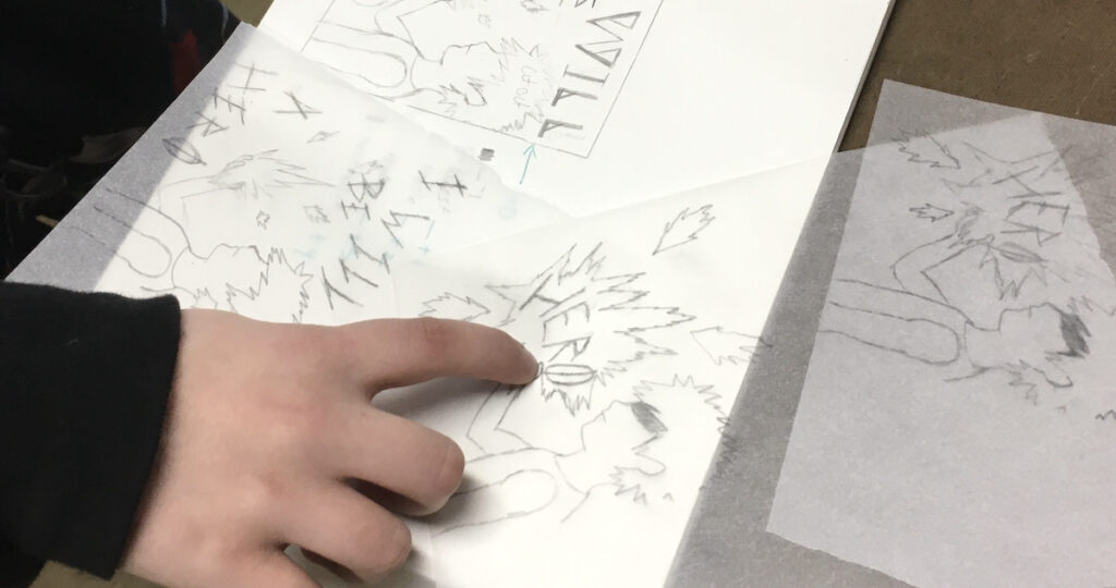 Student pointing at a drawing in a sketchbook