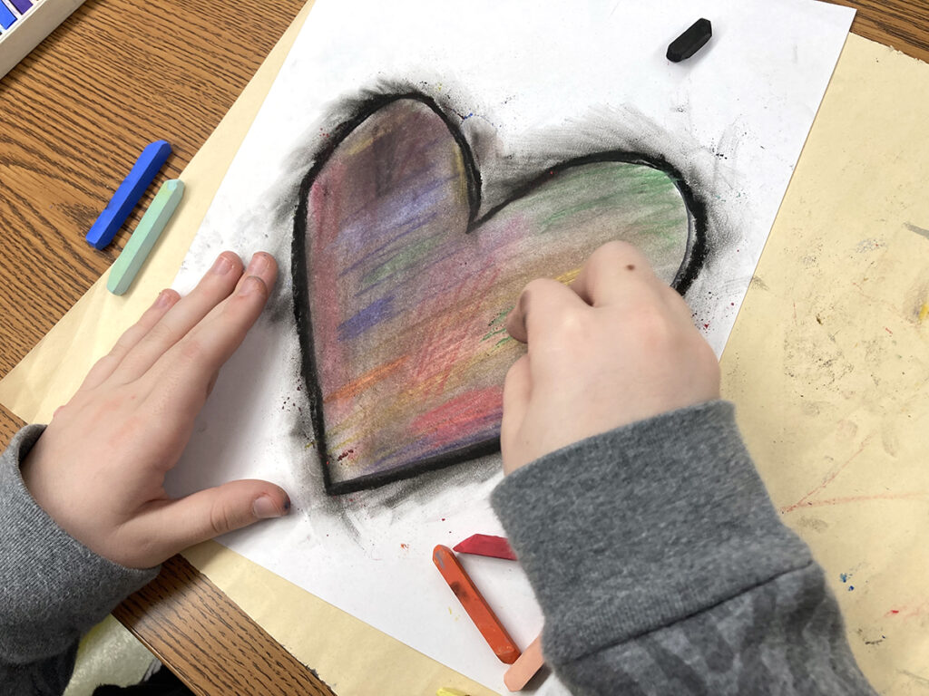 student drawing heart