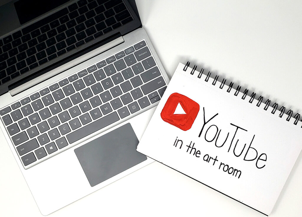 laptop and sketchbook with youtube logo