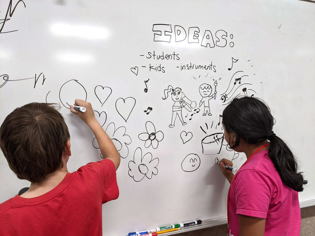 students drawing on whiteboard